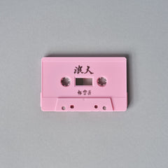 Pink cassette tape with Japanese characters written on it.