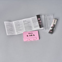 Pink audio cassette tape with accompanying printed materials.